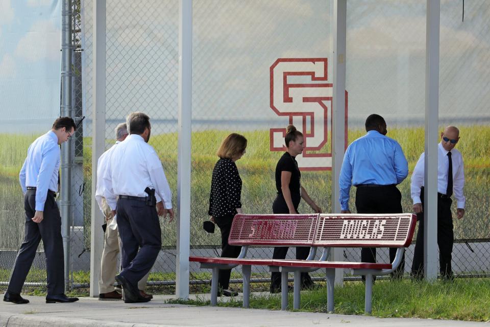 Members of the prosecution team including, from left, Assistant State Attorney Steven Klinger, legal assistant Aaron Savitski, public information officer Paula McMahon, Broward State Attorney Harold F. Pryor, Assistant State Attorney Nicole Chiappone, and Assistant State Attorney Mike Satz, walk toward the entrance at Marjory Stoneman Douglas High School in Parkland on Thursday, August 4, 2022, to view the “1200 building,” the crime scene where the 2018 shootings took place.