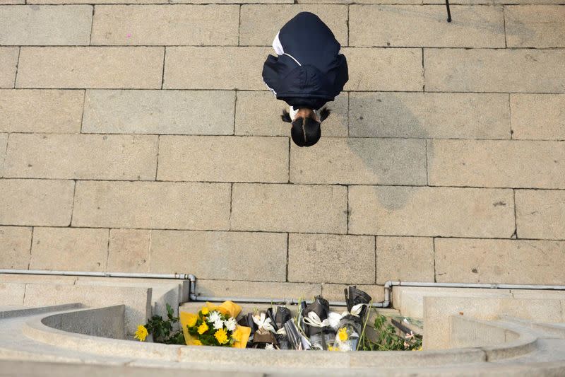 Girl bows to a martyrs tower at a park in Changsha