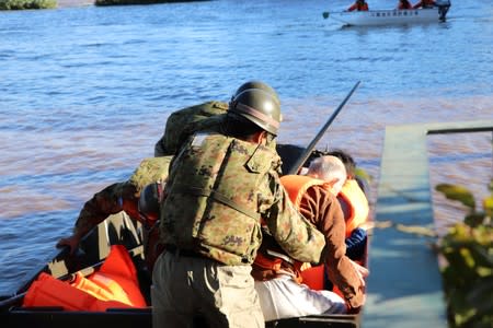 Rescue workers help residents evacuate an area after a typhoon swept through Kawagoe, Saitama prefecture