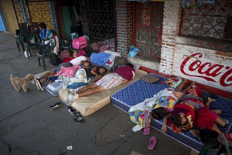 Children lie on mattresses on sidewalks outside stores near their homes after several earthquakes in Managua, Nicaragua, just after sunrise Monday, April 14, 2014. The government is recommending people sleep outside after an earthquake occurred a bit further away from Managua Sunday morning, following quakes on Thursday and Friday. (AP Photo/Esteban Felix)