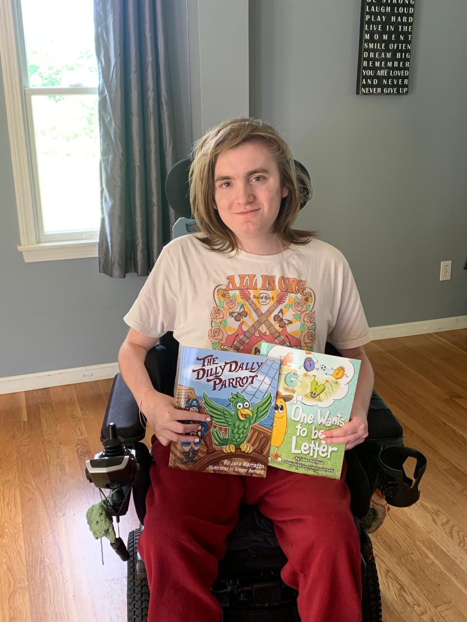 Jake Marrazzo at his Hudson home with his two children's books, "The Dilly Dally Parrot" and "One Wants to be a Letter."