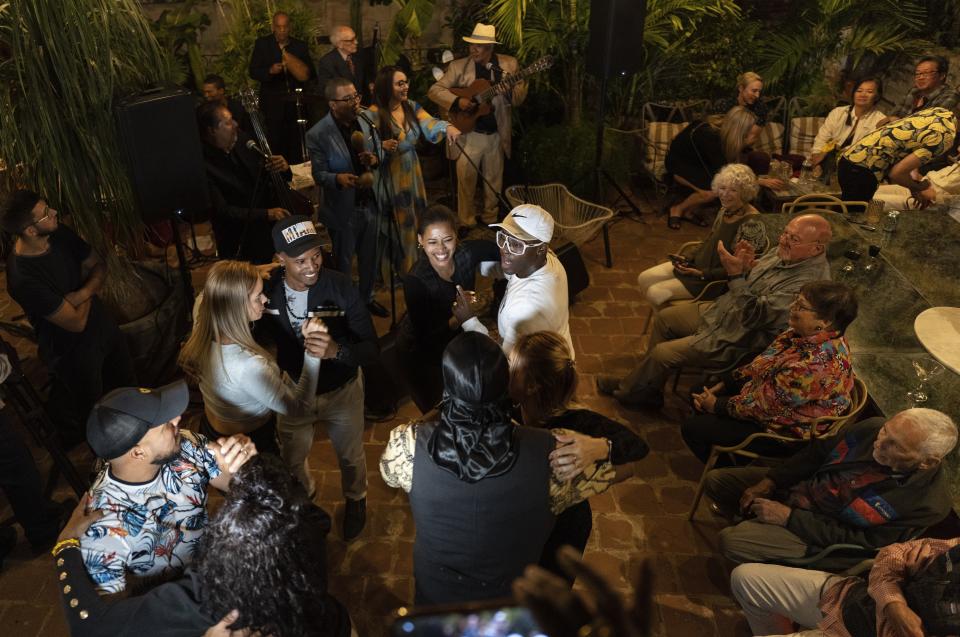 La gente baila durante un concierto de la cantante de bolero Idania Valdés en la terraza de un hotel en La Habana Vieja en La Habana, Cuba, el domingo 21 de enero de 2024. (AP Foto/Ramón Espinosa)