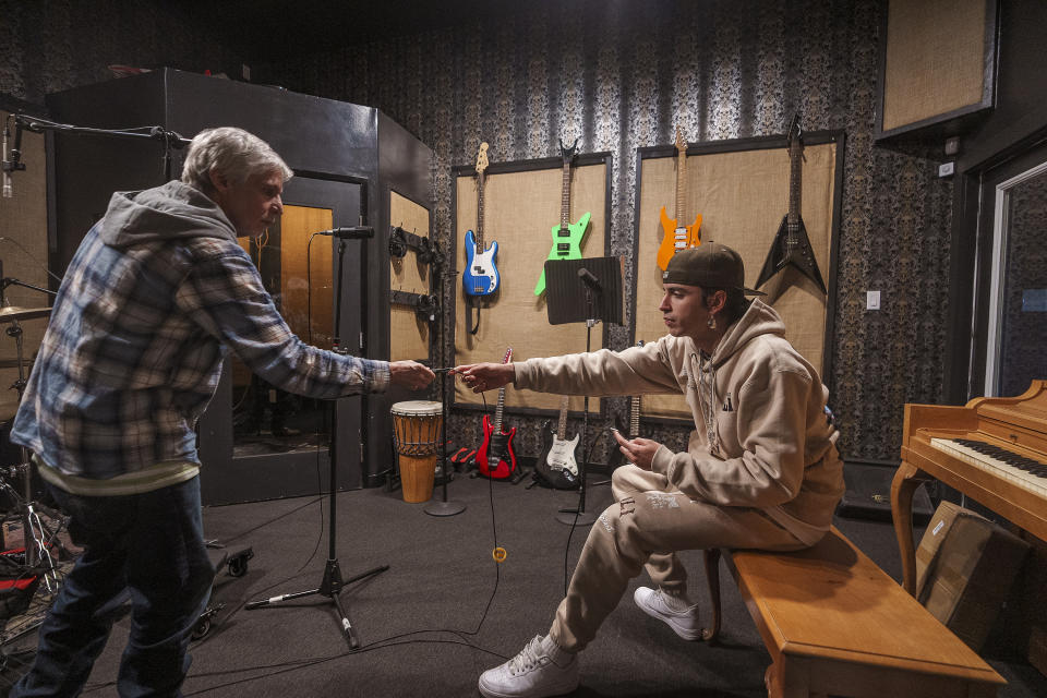 Professional recording engineer, Mike Fennel, left, teaches student Raashey how to wire recording microphones for a drumming session at the studio in Los Angeles Friday, Feb. 9, 2024. In recent years, Jail Guitar Doors USA spun off a partner nonprofit, the Community Arts Programing and Outreach Center, CAPO. Its headquarters in Hollywood includes a recording studio and teaches multimedia production to young people recently released from custody. (AP Photo/Damian Dovarganes)