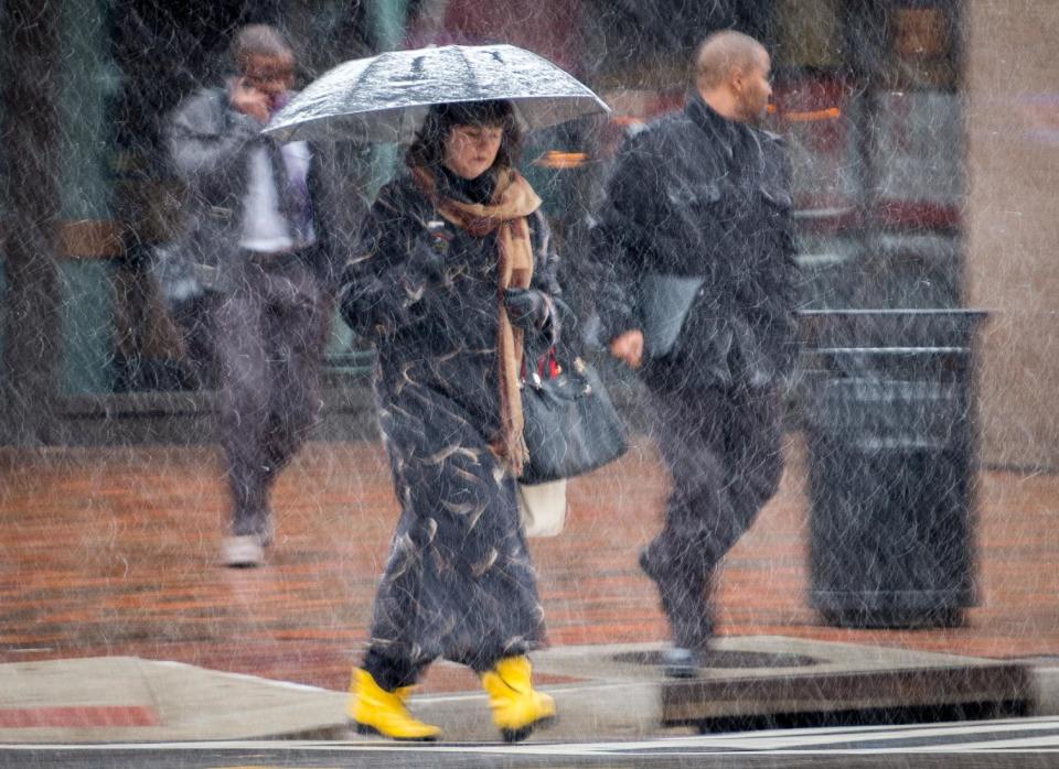 Early morning commuters walk through snow flurries in Washington, Tuesday, March 25, 2014. As the East Coast shivers through an unusually cold early spring, parts of the Mid-Atlantic and New England are bracing for a nor'easter that could bring additional snow. The National Weather Service says a powerful low pressure system will develop off the Mid-Atlantic coast Tuesday night. Where and how much snow falls will depend on the storm's track, according to the weather service. But, cold temperatures and windy conditions will cover the Mid-Atlantic states north into New England. (AP Photo/J. David Ake)