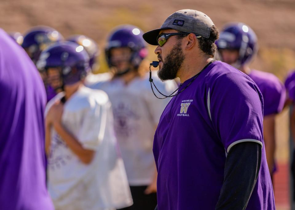 Wickenburg High School head football coach Ishmael MacNeil blows his whistle during practice at the school's football field.