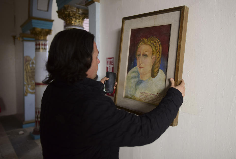 Jose Graziani removes a painting after an earthquake struck Puerto Rico before dawn, in Ponce, Puerto Rico, Tuesday, Jan. 7, 2020. (AP Photo/Carlos Giusti)