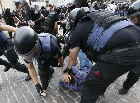 Riot police officers detain an anti-LGBT protester during the Equality March, organized by activists of the LGBT community, in Kiev, Ukraine June 17, 2018. REUTERS/Valentyn Ogirenko