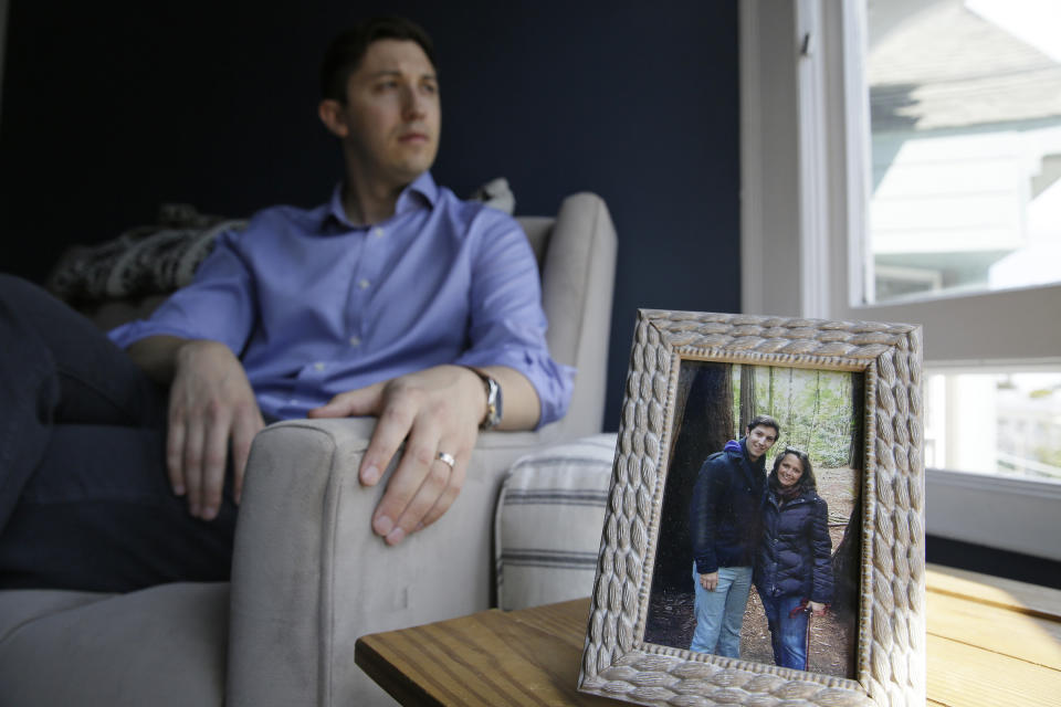 Dane Shikman sits by a photograph showing him with mother, Elizabeth Gaunt, at his home in San Francisco on Friday, April 19, 2019. Shikman's mother killed herself in 2015 at the Lake County, Calif., jail, after she was picked up for acting erratically. Gaunt, who had a history of mental health and substance abuse problems, had repeatedly screamed for help and pleaded to see a doctor. Her son’s wrongful death lawsuit resulted in a $2 million county settlement. (AP Photo/Eric Risberg)