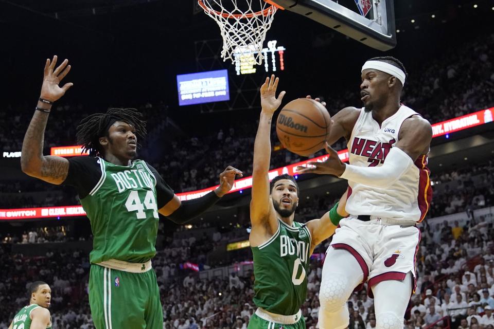 Boston Celtics center Robert Williams III (44) and forward Jayson Tatum (0) attempt to block a pass by Miami Heat forward Jimmy Butler (22) during the second half of Game 1 of an NBA basketball Eastern Conference finals playoff series, Tuesday, May 17, 2022, in Miami. (AP Photo/Lynne Sladky)