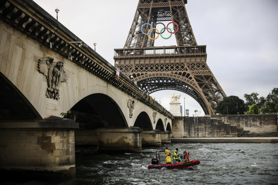 A rescue boat cruises on the Seine river near the Eiffel Tower during a rehearsal for the Paris 2024 Olympic Games opening ceremony, Monday, June. 17, 2024 in Paris. The river will host the Paris 2024 Olympic Games opening ceremony on July 26 with boats for each national delegation. (AP Photo/Thomas Padilla)