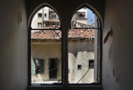A heritage house that was damaged by Aug. 4 explosion that hit the seaport of Beirut, is seen through a broken window of other heritage house, in Beirut, Lebanon, Tuesday Aug. 25, 2020. In the streets of Beirut historic neighborhoods, workers are erecting scaffolding to support buildings that have stood for more than a century - now at risk of collapse after the massive Aug. 4 explosion that tore through the capital. (AP Photo/Hussein Malla)