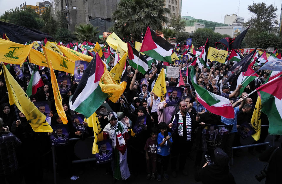 Iranian protesters wave Iranian, Palestinian and Lebanon's militant Hezbollah group flags in a demonstration to condemn killing of Hamas leader Ismail Haniyeh, at Felestin (Palestine) Sq. in Tehran, Iran, Wednesday, July 31, 2024. Haniyeh was assassinated in Tehran, Iran's paramilitary Revolutionary Guard said early Wednesday. (AP Photo/Vahid Salemi)