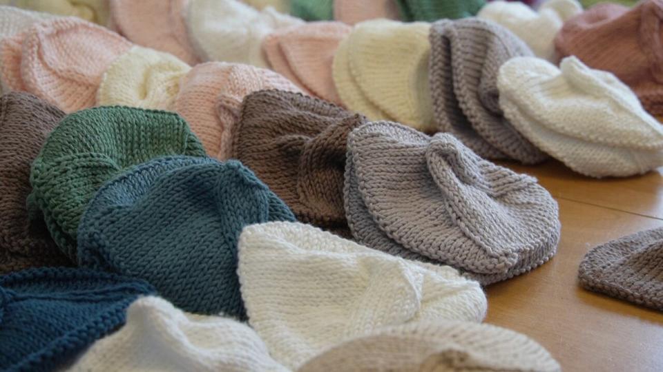 Rows of unfilled knitted knockers lined Doucet's dining room table as she prepared to mail off another box. 