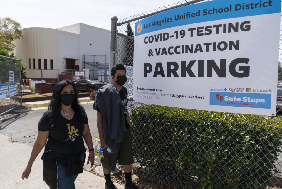 FILE - In this April 15, 2021, file photo, parent Rosa Vargas and her son, 9th grade student Victor Loredo, 14, walk home after getting tested at a Los Angeles Unified School District COVID-19 testing and vaccination site in East Los Angeles. Children are having their noses swabbed or saliva sampled at school to test for the coronavirus in cities. As more children return to school buildings this spring, widely varying approaches have emerged on how and whether to test students and staff members for the virus. (AP Photo/Damian Dovarganes, File)