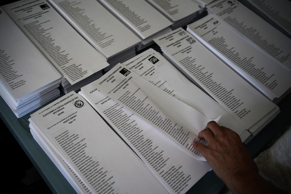 A voter picks a ballot for the Socialist Party at a polling station for Spain's general election, in Madrid, Sunday, July 23, 2023. Sunday's election could make the country the latest European Union member to swing to the populist right, a shift that would represent a major upheaval after five years under a left-wing government. (AP Photo/Andrea Comas)