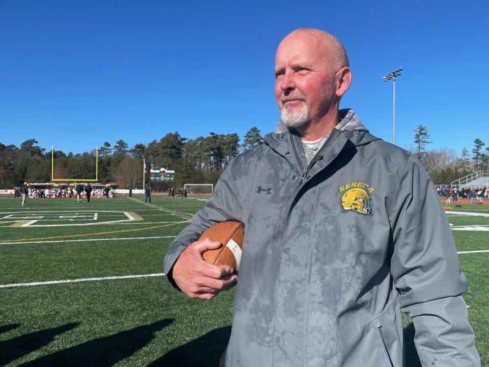 Seneca football coach Bill Fisher clutches the game ball following a 13-6 win over Cherokee on Thanksgiving, Nov. 23, 2023. It was the final game for Fisher, who started the program in 2003.