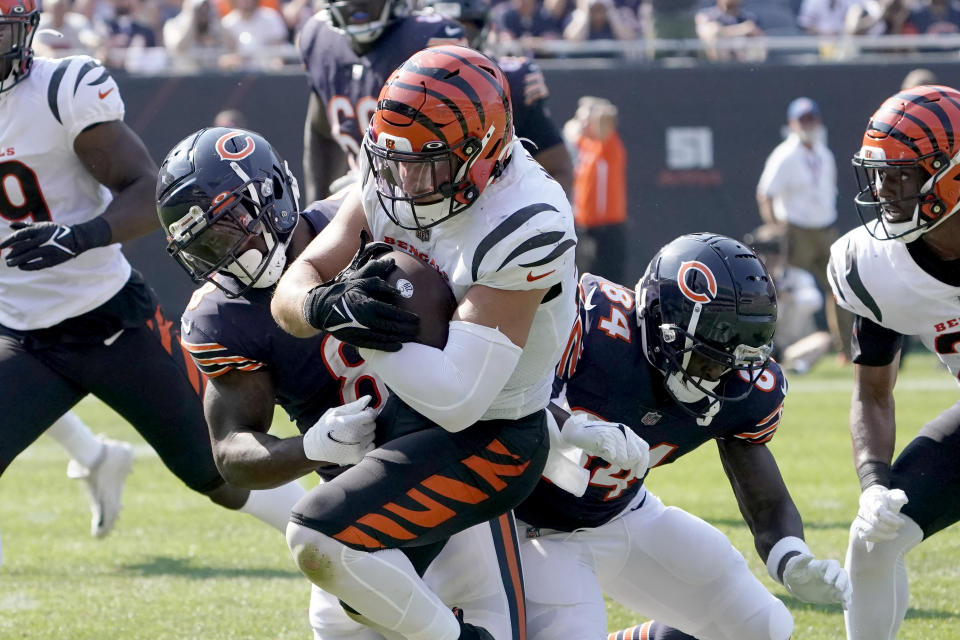 Cincinnati Bengals linebacker Logan Wilson advances his interception of Chicago Bears quarterback Justin Fields as Chicago Bears running back Damien Williams and Marquise Goodwin make the tackle during the second half of an NFL football game Sunday, Sept. 19, 2021, in Chicago. The Bears won 20-17. (AP Photo/David Banks)
