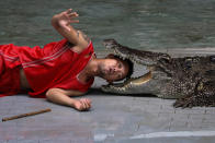 <p>A zoo performer reacts as he puts his head between the jaws of a crocodile during a performance for tourists at Sriracha Tiger Zoo, in Chonburi province, Thailand, May 16, 2017. (Photo: Athit Perawongmetha/Reuters) </p>