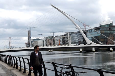 FILE PHOTO: A man walks past offices in the Irish Financial Services Centre in Dublin