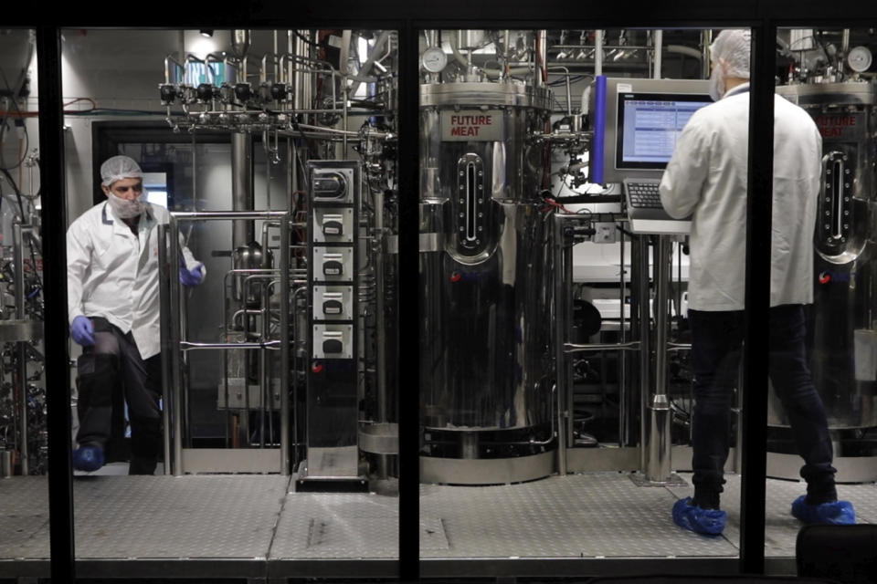 Technicians work with bioreactors at the Believer Meats facility in Rehovot, Israel on Feb. 13, 2023. Animal cells are placed inside bioreactors and bathed in a nutrient-rich broth where they multiply. The paste of cells is harvested and mixed with plant proteins, then pressurized and pushed out to create meat fibers. (AP Photo/Emma H. Tobin)