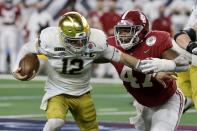 Notre Dame quarterback Ian Book (12) is sacked by Alabama defensive lineman Byron Young (47) in the second half of the Rose Bowl NCAA college football game in Arlington, Texas, Friday, Jan. 1, 2021. (AP Photo/Michael Ainsworth)