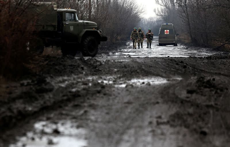Militares ucranianos caminan por un camino embarrado cerca de la ciudad de Bajmut