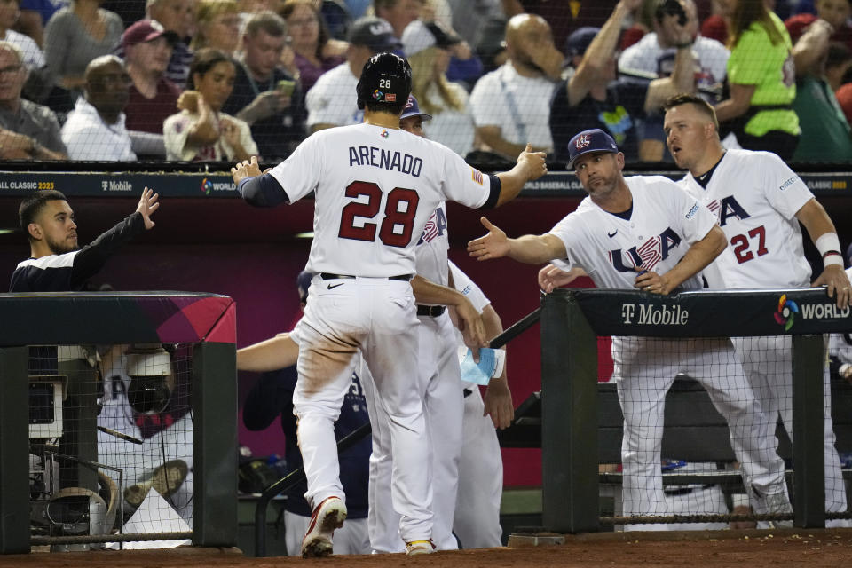 United States' Nolan Arenado (28) celebrates with teammates after scoring against Great Britain on a single by Kyle Tucker during the third inning of a World Baseball Classic game in Phoenix, Saturday, March 11, 2023. (AP Photo/Godofredo A. Vásquez)