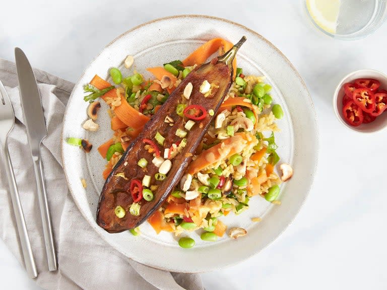 Roasted miso aubergine, edamame rice and cashewsSweet and sticky aubergine topped with a golden layer of umami-packed miso paste is roasted in the oven with ginger. Served with edamame rice with crunchy cashew nuts.100g fresh edamame beans 1/2 red chilli 1 aubergine 1 lime 200g carrot 20g cashew nuts 2 spring onions 2 tbsp sesame oil 2 tbsp sweet white miso paste 2 tsp tamari 4cm fresh ginger 80g brown rice Medium handful of fresh corianderPreheat the oven to 200C / gas mark 6 and boil a kettle. Rinse the brown rice and place in a saucepan with 400ml boiling water and a pinch of sea salt. Simmer for 20-25 minutes, then drain.Slice the aubergine in half lengthways. Lay the aubergine flesh side up on a baking tray, slice diagonally 1cm deep into the aubergine in a criss-cross pattern, being careful not to cut through the skin. Drizzle half of the sesame oil over the aubergine halves and place in the centre of the oven for 10 minutes until softening.Meanwhile, peel and cut the carrots into long thin strips using a peeler. Thinly slice the spring onions, removing the root ends. Finely chop the half red chilli (remove the seeds for less heat) and roughly chop the coriander leaves.Peel and finely grate the fresh ginger. In a small bowl, mix together the sweet miso paste with the fresh ginger. After the aubergine has been cooking for 10 minutes, spread 2/3 of this miso mix evenly over the aubergine (saving the remaining miso mix for the rice) and place back in the oven for 15 minutes or until the miso has turned golden and the aubergine has softened.Heat a large dry frying pan on a medium-high heat and toast the cashew nuts for 2-3 minutes until turning golden brown. Remove from the pan and set aside.Heat the same pan with the remaining sesame oil on a medium heat and cook the spring onions, half of the chilli and the remaining miso mix for 1 minute, then add the edamame beans and carrot and cook for 2 minutes. To the veggies, add the cooked brown rice, chopped coriander, tamari and half of the juice from the lime and cook for a further 2 minutes.Spoon the edamame rice onto two warm plates and top with the roasted miso aubergine. Sprinkle over the toasted cashew nuts and remaining chilli (to taste). Squeeze over the remaining lime juice.Recipe from Mindfulchef.com