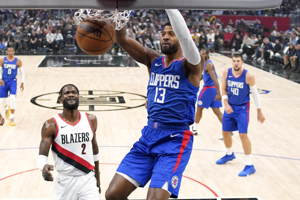 Los Angeles Clippers forward Paul George, center, dunks as Portland Trail Blazers Deandre Ayton, second from left, watches during the first half of an NBA basketball game Wednesday, Oct. 25, 2023, in Los Angeles. (AP Photo/Mark J. Terrill)