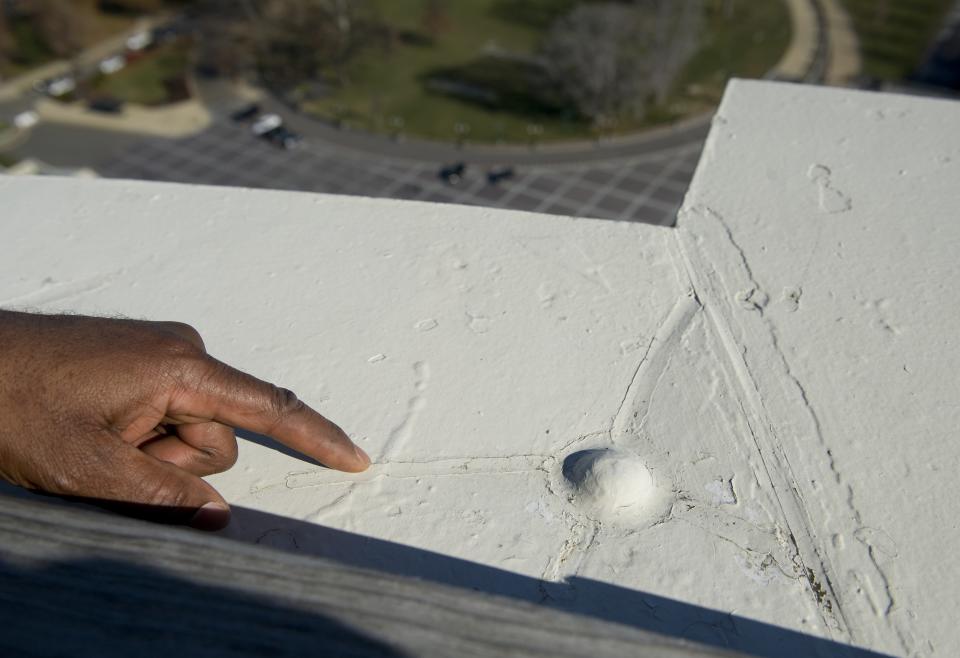 Project manager points out repair work done to the U.S. Capitol dome while atop the dome in Washington