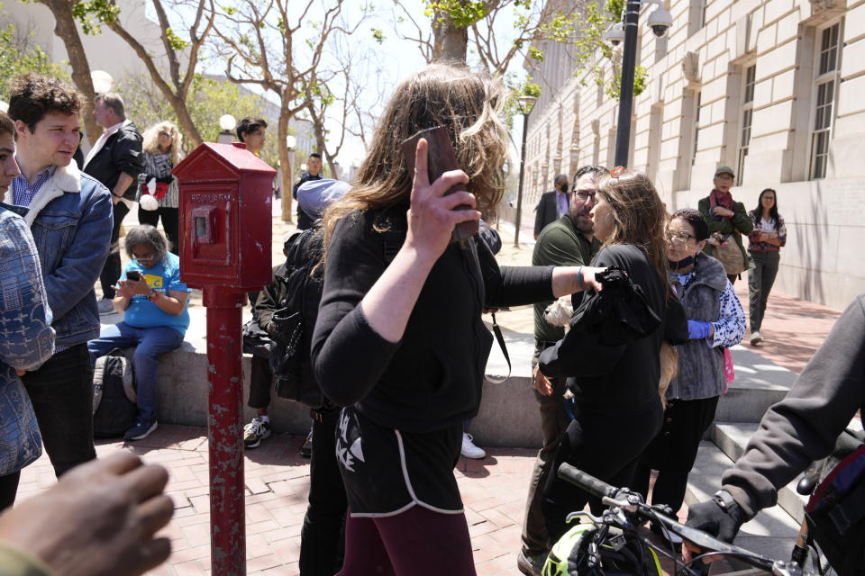 A protester prepares to throw a brick at a color guard following a rare outdoor meeting of the Board of Supervisors at UN Plaza in San Francisco, Tuesday, May 23, 2023. Mayor London Breed attempted to answer questions from supervisors demanding her administration do more to shut down open-air drug dealing, but the meeting had to be moved indoors to City Hall because of disruptions. (AP Photo/Eric Risberg)