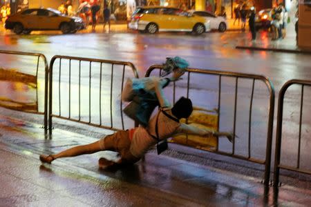 A woman falls as Typhoon Nesat hits Taipei, Taiwan July 29, 2017. REUTERS/Tyrone Siu
