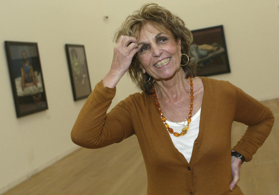 FILE - Portuguese-British artist Paula Rego reacts during an interview next to some of her paintings at the Serralves Museum, Oct. 15, 2004 in Porto, northern Portugal. Rego, who created bold, visceral works inspired by fairy tales, her homeland and her own life, has died on Wednesday, June 8, 2022 at the age of 87. (AP Photo/Paulo Duarte, File)