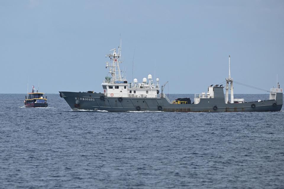 A large Chinese ship approaches a smaller Philippine ship in the open Ocean.