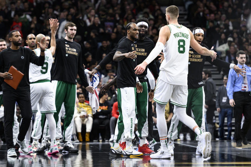 Boston Celtics center Kristaps Porzingis (8) celebrates with teammates after the Celtics defeated the Toronto Raptors in an NBA basketball game Friday, Nov. 17, 2023, in Toronto. (Christopher Katsarov/The Canadian Press via AP)