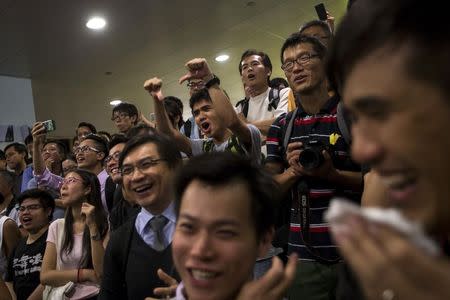 Protesters of the Occupy Central movement gesture at anti-Occupy Central protesters while blocking an area outside government headquarters in the Admiralty district in Hong Kong October 7, 2014. REUTERS/Tyrone Siu