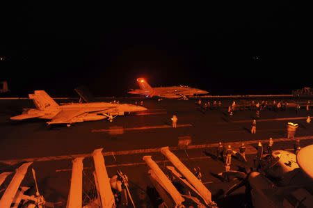 An F/A-18E Super Hornet, attached to Strike Fighter Squadron (VFA) 31, and an F/A-18F Super Hornet, attached to Strike Fighter Squadron (VFA) 213, prepare to launch from the flight deck of the aircraft carrier USS George H.W. Bush (CVN 77) to conduct strike missions against ISIL targets, in the Arabian Gulf in this U.S. Navy handout photograph provided September 23, 2014. REUTERS/U.S. Navy/Mass Communication Specialist 3rd Class Robert Burck/Handout via Reuters