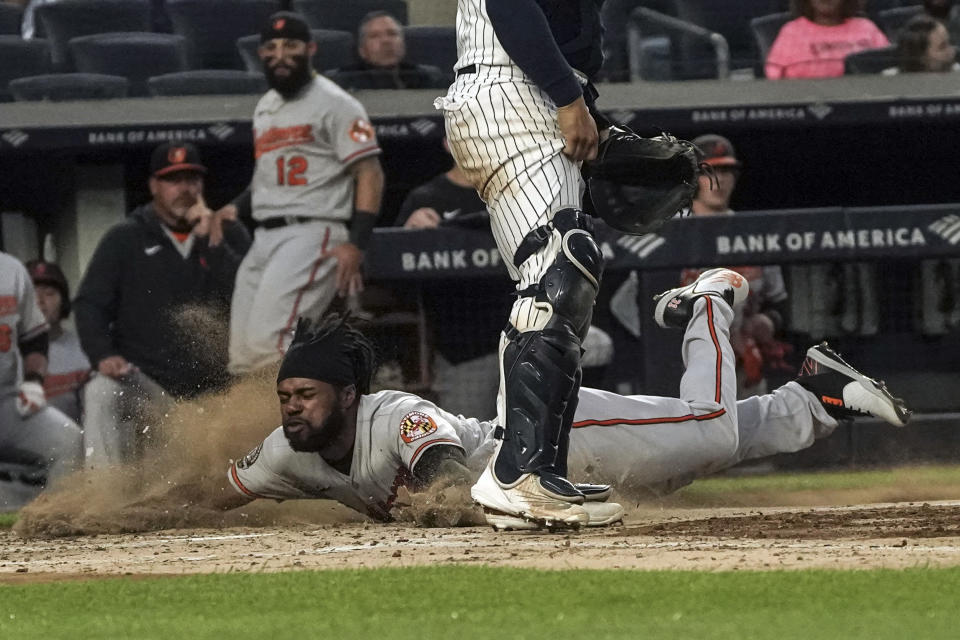 Baltimore Orioles' Cedric Mullins, left, slides home safely during the third inning of a baseball game against the New York Yankees, Monday May 23, 2022, in New York. (AP Photo/Bebeto Matthews)