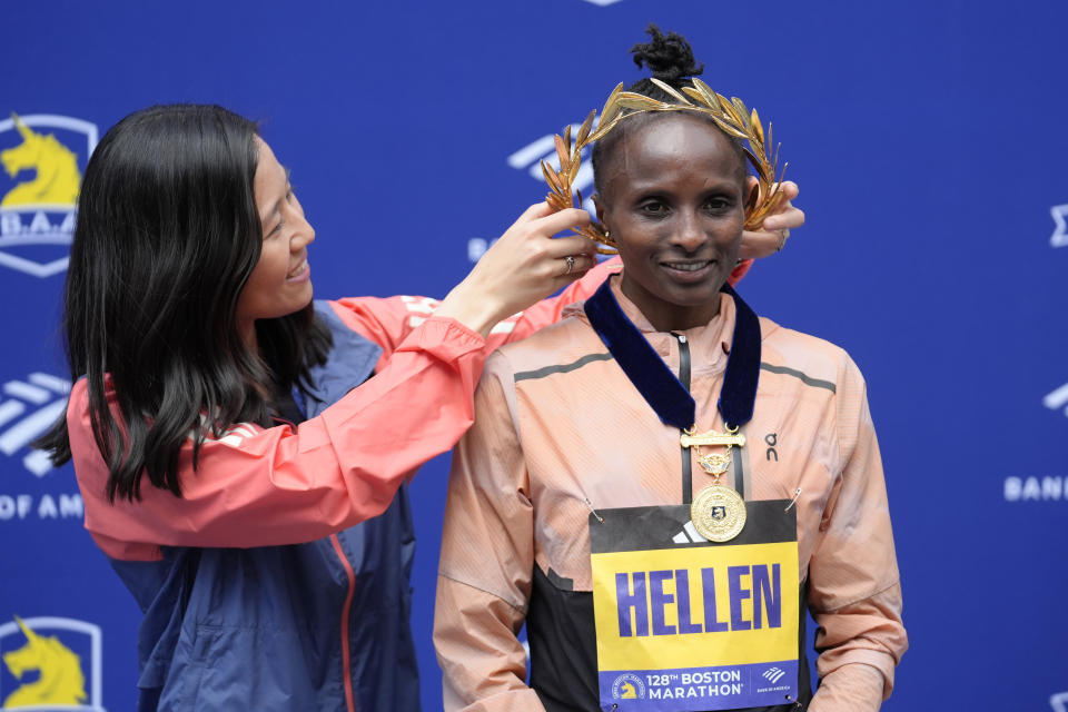 Boston Mayor Michelle Wu, left, places a wreath on Hellen Obiri, of Kenya, right, winner of the women's division of the Boston Marathon, during ceremonies, Monday, April 15, 2024, in Boston. (AP Photo/Steven Senne)