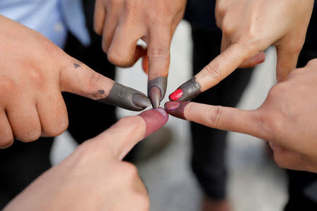 Cambodian voters take pictures of their ink stained fingers after they voted, outside a polling station during a general election in Phnom Penh, Cambodia July 29, 2018. REUTERS/Darren Whiteside