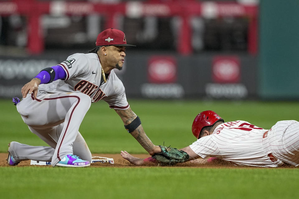 Philadelphia Phillies' Kyle Schwarber is tagged out stealing by Arizona Diamondbacks second baseman Ketel Marte during the eighth inning in Game 6 of the baseball NL Championship Series in Philadelphia Monday, Oct. 23, 2023. (AP Photo/Brynn Anderson)