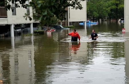 Men look for people wanting to be evacuated from the Hurricane Harvey floodwaters in Dickinson, Texas, U.S., August 28, 2017. REUTERS/Rick Wilking/Files