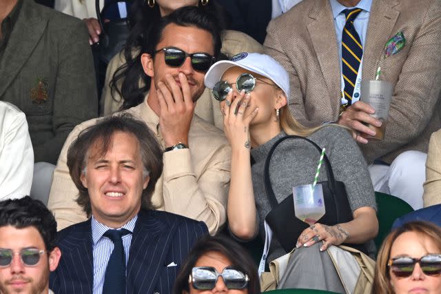 <p>Karwai Tang/WireImage</p> Jonathan Bailey and Ariana Grande share a laugh at Wimbledon.