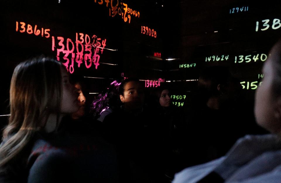 Students from Islands High School watch from all angles as numbers flash across the walls of the cattle car symbolizing the identification numbers given to Jews during the Holocaust as they participate in the Hate Ends Now Cattle Car on Thursday January 5, 2023.