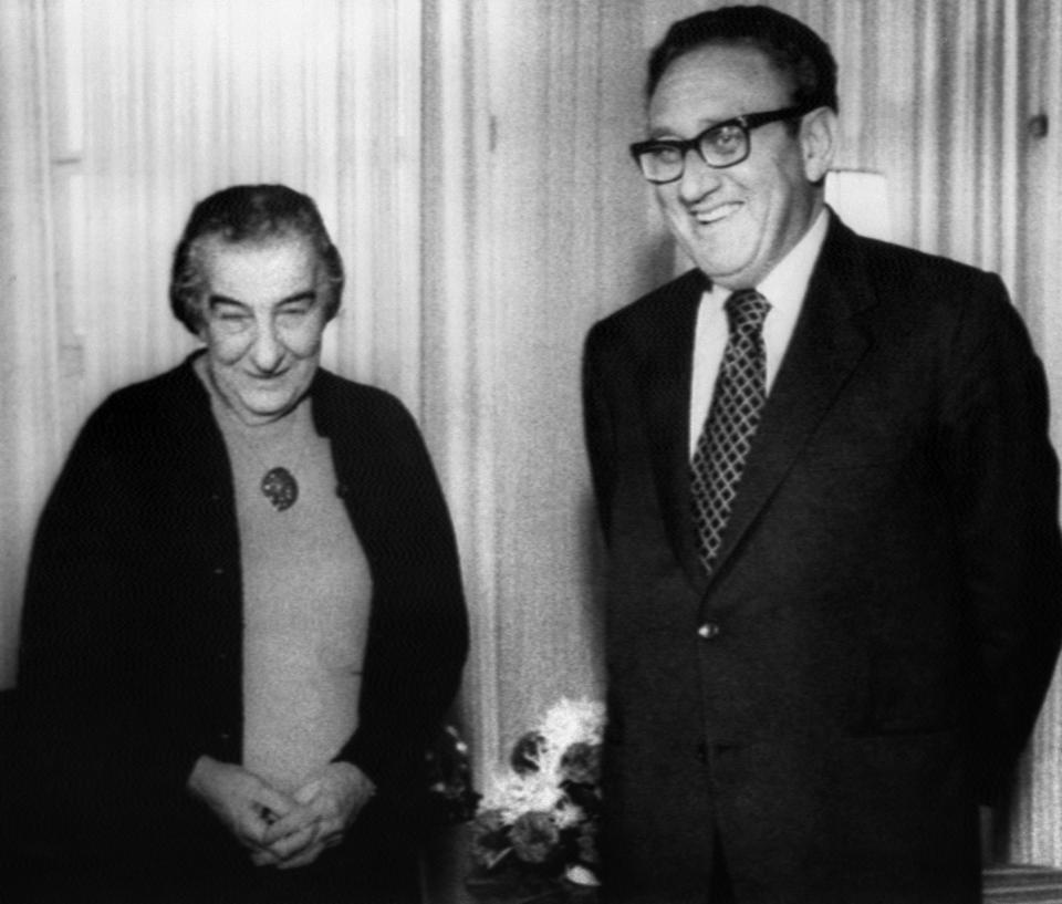 A black and white photo of American Secretary of State Henry Kissinger (Right) standing next to Israeli Prime Minister Golda Meir (Left