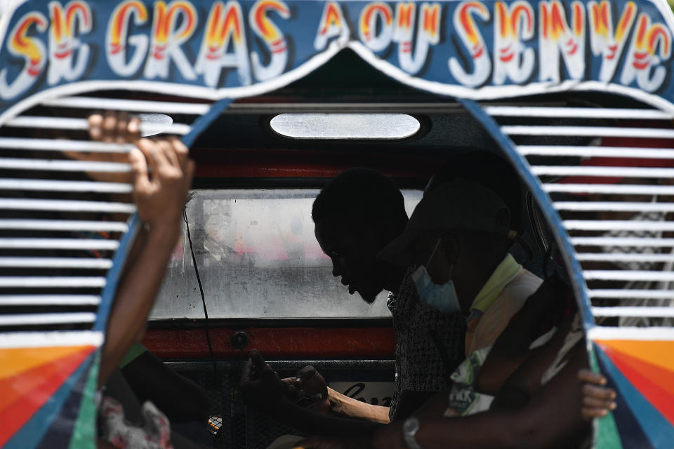 Commuters travel on a bus popularly referred to as "tap-tap" in Port-au-Prince, Haiti, Thursday, July 15, 2021, just over a week since Haitian President Jovenel Moise was assassinated in his home. Authorities in Haiti on Thursday forcefully pushed back against reports that current government officials were involved in the killing of Haitian President Jovenel Moïse, calling them “a lie.” (AP Photo/Matias Delacroix)