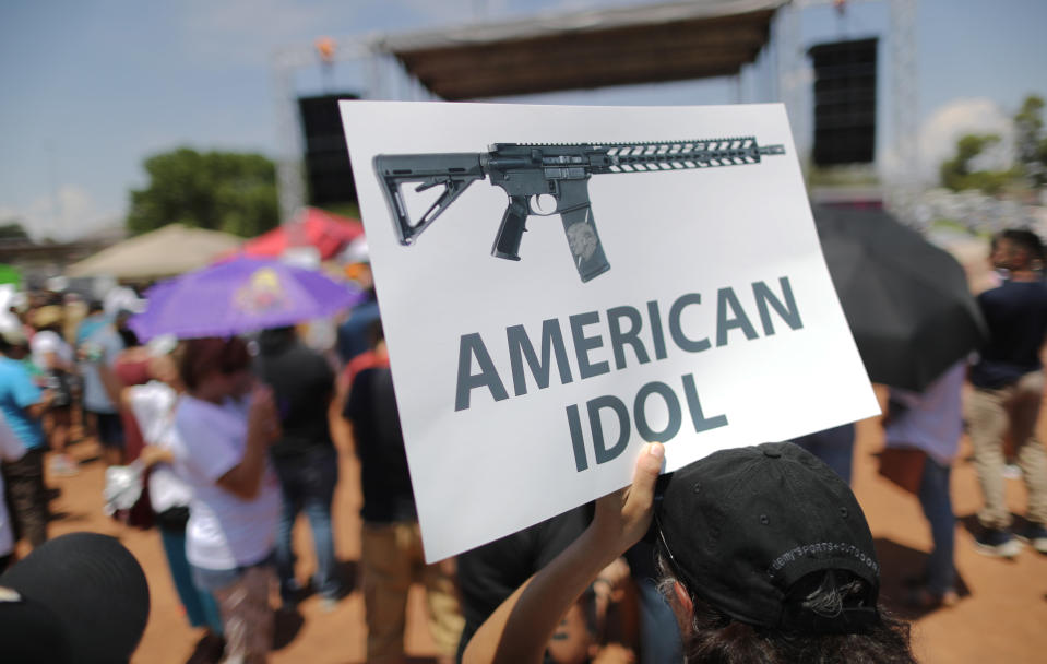 A demonstrator holds a sign depicting an assault rifle at a protest against President Trump's visit, following a mass shooting which left at least 22 people dead, on Aug. 7, 2019 in El Paso, Texas. (Photo: Mario Tama/Getty Images)