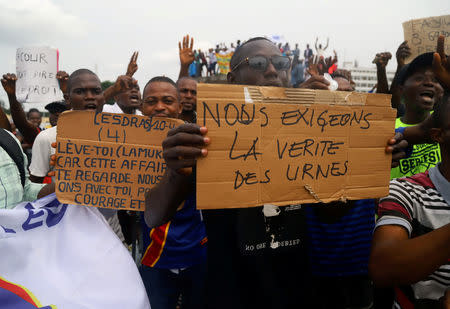 FILE PHOTO: Supporters of Martin Fayulu, runner-up in Democratic Republic of Congo's presidential election, chant slogans and carry placards as he delivers his appeal contesting the Congo's National Independent Electoral Commission (CENI) results of the presidential election at the constitutional court in Kinshasa, Democratic Republic of Congo, January 12, 2019. REUTERS/Kenny Katombe/File Photo