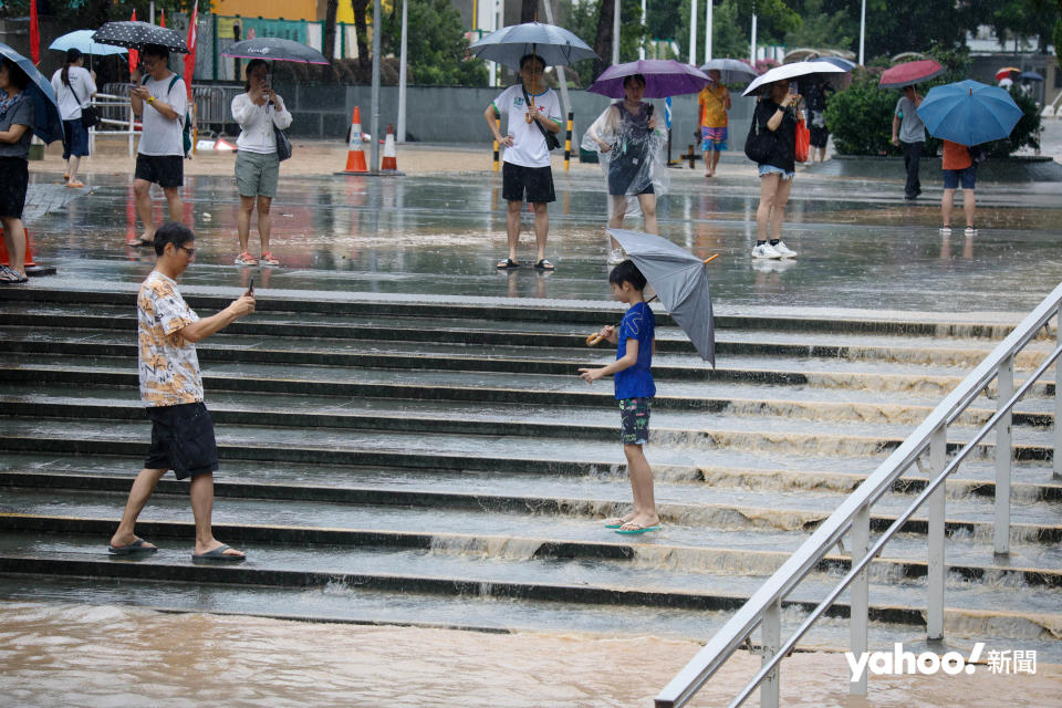 本港遭遇世紀豪雨，黃大仙成為水浸重災區，通往黃大仙祠的樓梯水浸彷如瀑布，街坊涉水而行，有人則趁機打卡留念。