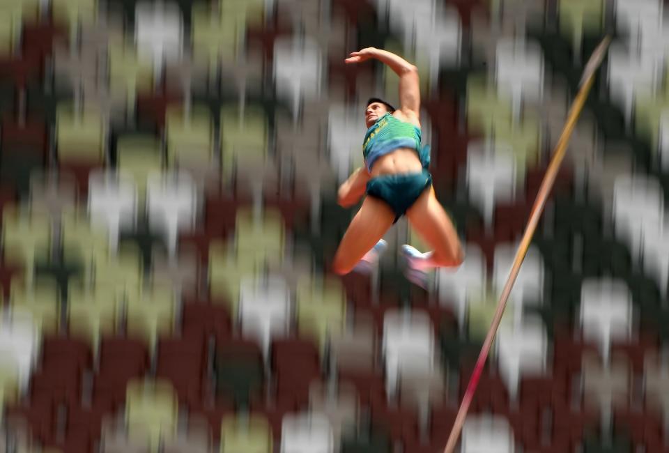 A man is bent midair; the background is blurry.